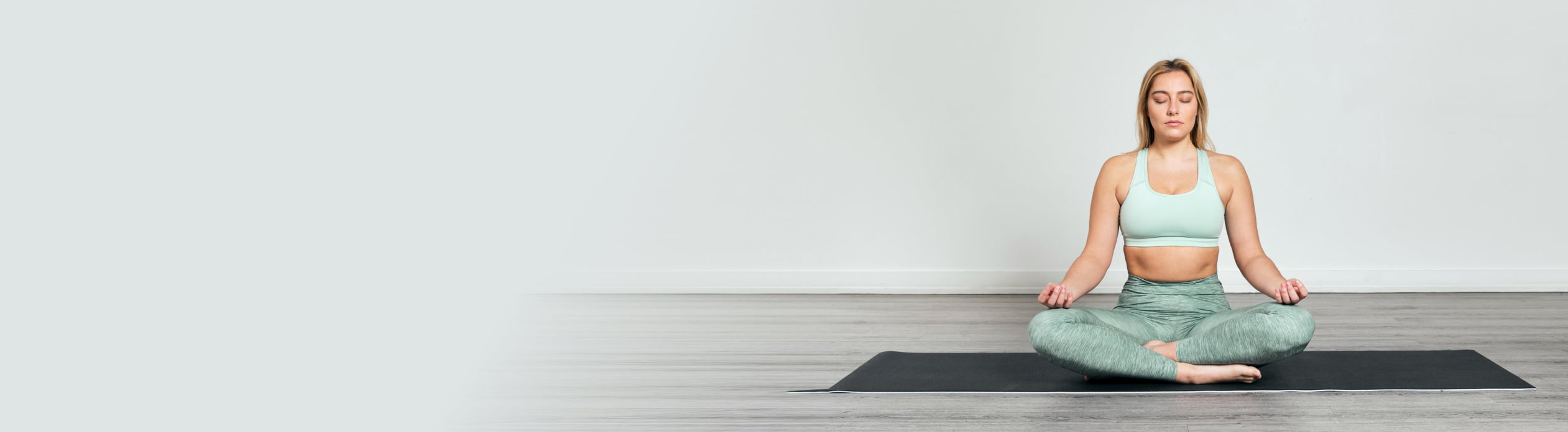 Woman mindfully meditating with eyes closed on the floor